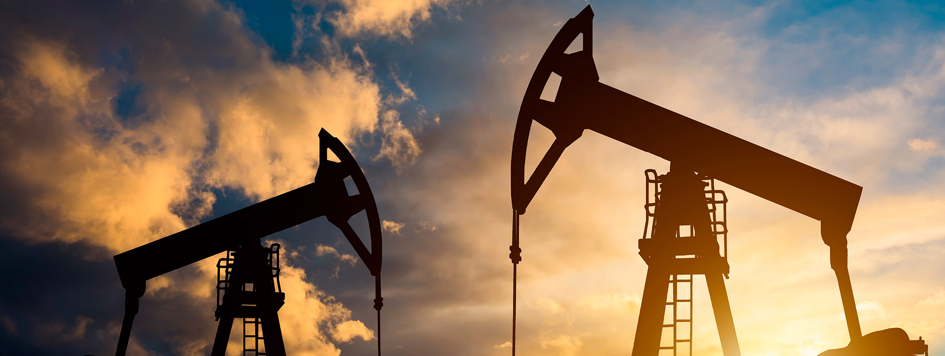 Oil pumpjacks silhouetted against a warm sky