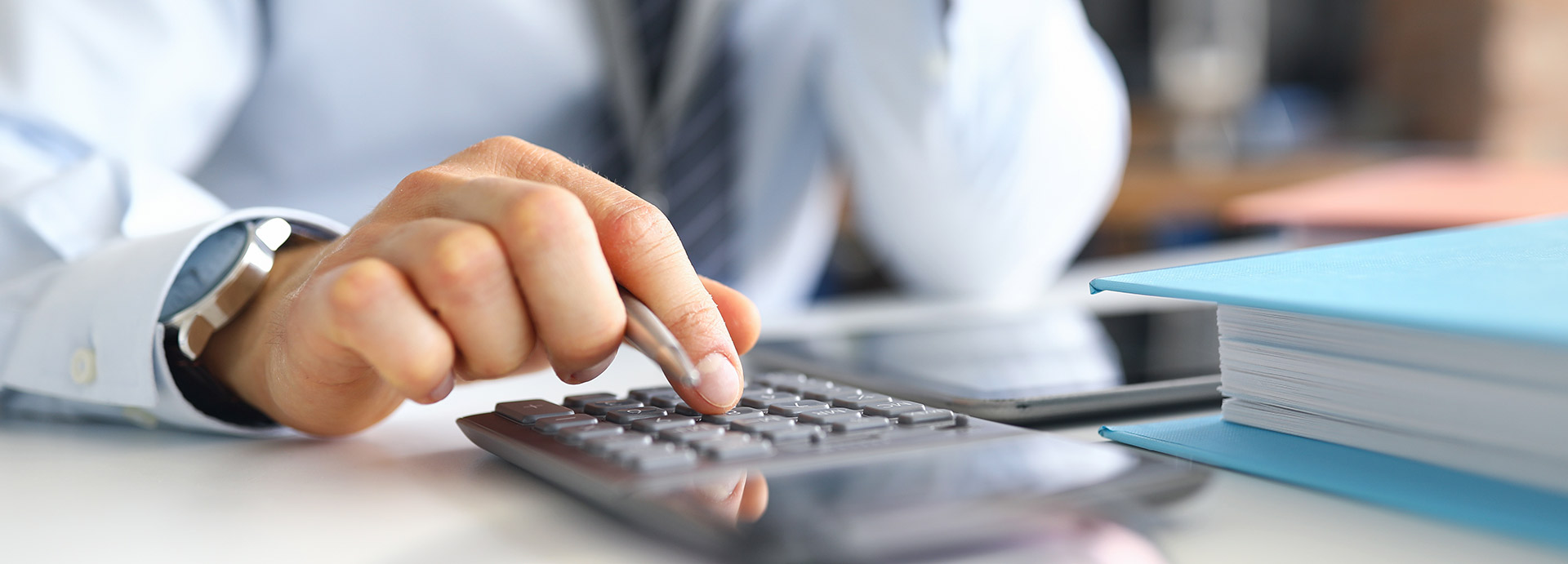 Person using a calculator beside tax records